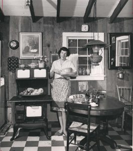 Celestine Sibley stands in a kitchen with a bowl in her hand.